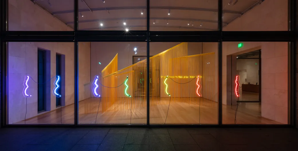 "Neon sculpture of the outline of a pregnant body in the colors of the rainbow"