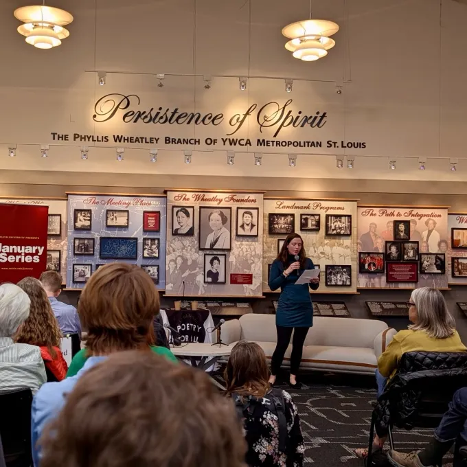 "Laura Evers stands in front of an audience at the Phyllis Wheatley YWCA"