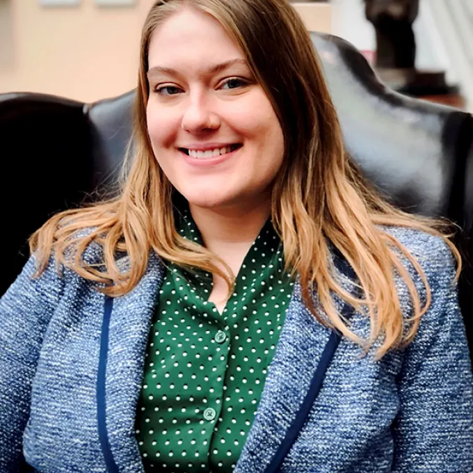 "photo of a woman in a blue jacket and green shirt"