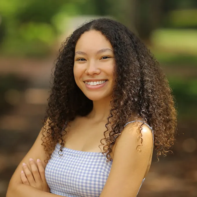 "woman wearing a gingham shirt in an outdoor setting"